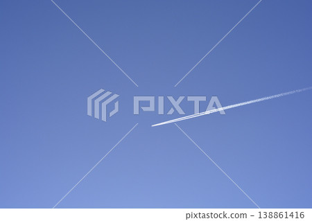 Airplane condensation trail in clear blue sky 138861416