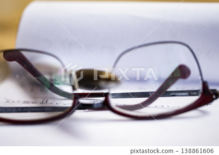 Reading glasses on handwritten notes with shallow depth of field 138861606