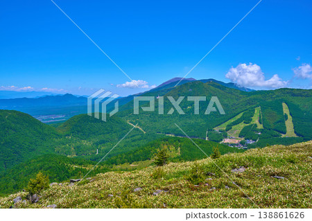 View to the east from the summit of Mt. Yunomaru in Tsumagoi Village, Agatsuma District, Gunma Prefecture, amidst the fresh greenery of spring (including Mt. Asama, Mt. Nishikagonotoyama, Mt. Higashikagonotoyama, etc.) 138861626
