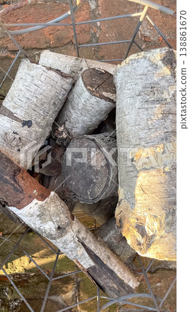 Top view of birch firewood logs Betula pendula stacked in a metal wire basket in a rustic garden 138861670