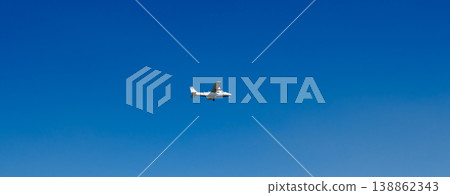 Small airplane flying in clear deep blue sky with minimalist composition and copy space aviation travel 138862343
