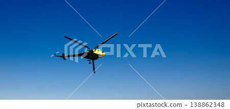 Yellow and black helicopter flying in clear blue sky copy space banner background 138862348