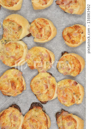 Baked puff pastry rolls with cheese cream, cheese and ham 138863402