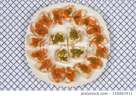 Vegan Salmon Carrots and Pistachio Topped Bruschettas on a Patterned Tablecloth 138863411