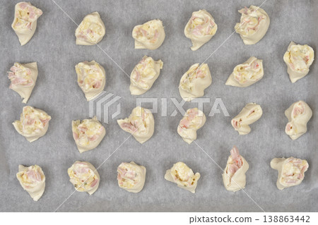 Raw puff pastry rolls with cheese cream, cheese and ham 138863442