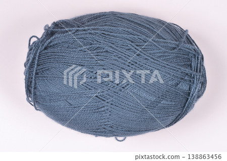 Ball of grey wool yarn on beige background Ball of grey wool yarn on beige background 138863456