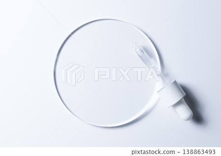 A glass circle on a blue background. A template for placing samples of cosmetics or medical products or food. 138863493