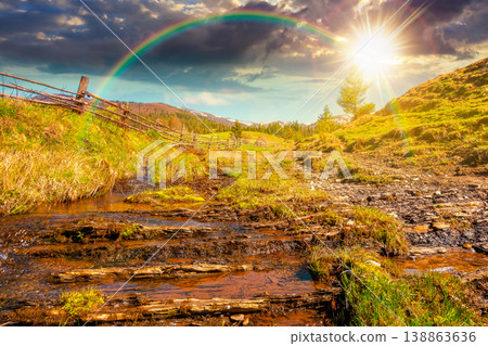 sunset over rural scenery in carpathian mountains. simple view of a countryside mountain landscape during springtime. brook near the grassy hills. weather with rainbow 138863636