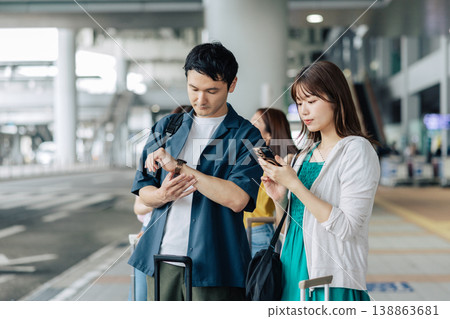 A couple waiting for a taxi (or bus) at their travel destination. (Photo courtesy of Kansai International Airport (KIX)) A couple waiting for a taxi (or bus) at their travel destination. (Photo courtesy of Kansai International Airport (KIX)) 138863681