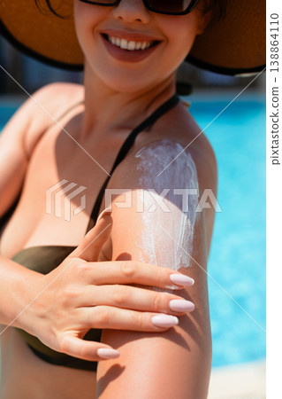 Woman Smiling While Applying Sunscreen On Shoulder Close Portrait In Summer Sunlight. Skincare And Sun Protection Concept With Healthy Skin Glow 138864110