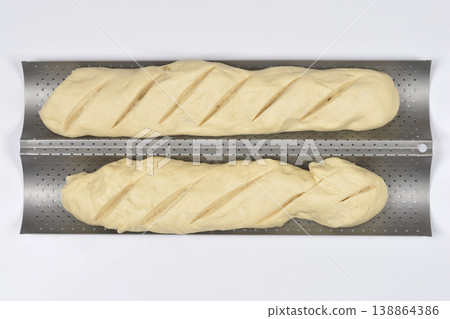 Raw baguette dough on a baking tray Raw baguette dough on a baking tray 138864386