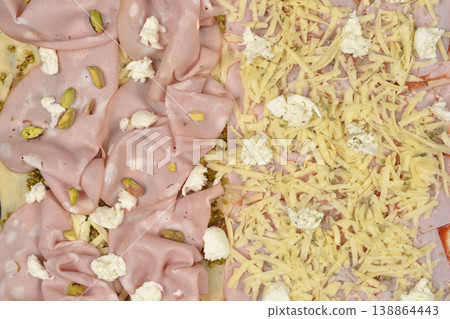 Pizza with mortadella pistachios and grated cheese topping Pizza with mortadella pistachios and grated cheese topping 138864443