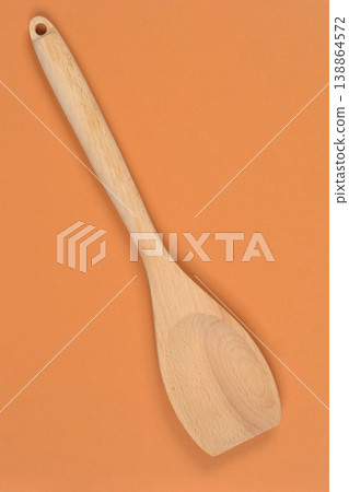 Wooden spatula on orange background Wooden spatula on orange background 138864572