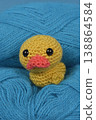 Close up of Crocheted Yellow Duckling on Blue Yarn 138864584