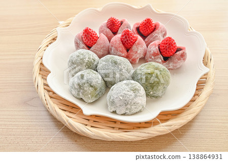 A combination of mugwort mochi and strawberry daifuku. A combination of mugwort mochi and strawberry daifuku. 138864931