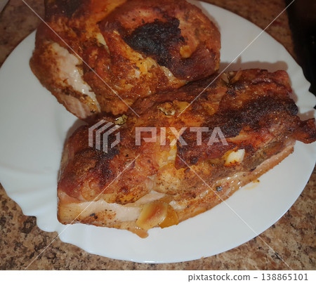 Appetizing baked meat with spices and garlic on a white plate. Juicy pork with a ruddy crust, cooked at home Appetizing baked meat with spices and garlic on a white plate. Juicy pork with a ruddy crust, cooked at home 138865101