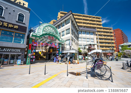 The entrance to the "Dogo Haikara Street" arcade in front of Dogo Onsen Station and a scene of a rickshaw. 138865687