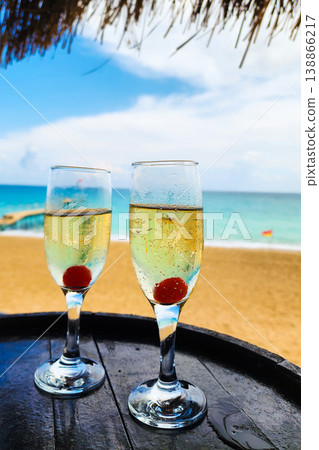 Two champagne flutes with cherries on tropical beach Two champagne flutes with cherries on tropical beach 138866217