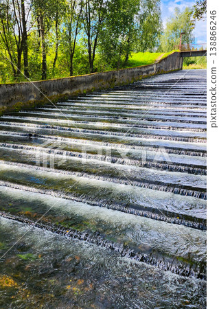 Water flowing over stepped river weir in nature Water flowing over stepped river weir in nature 138866246