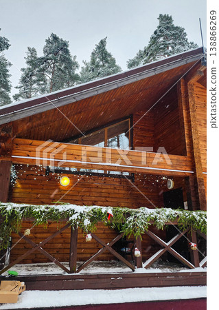Log cabin exterior in winter with snow falling Log cabin exterior in winter with snow falling 138866269