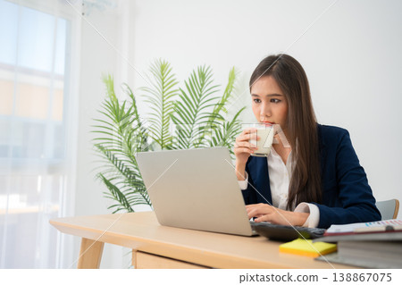 Portrait of smiling beautiful business asian woman at modern office desk using laptop to work and write notes, Business people employee freelance online marketing e-commerce telemarketing concept. 138867075