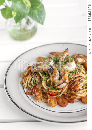 shrimp and tomato diavolo spicy spaghetti on white table at outdoor restaurant in italy 138868106