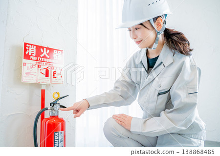 一名身穿工作服的女子正在檢查消防安全設備。 138868485