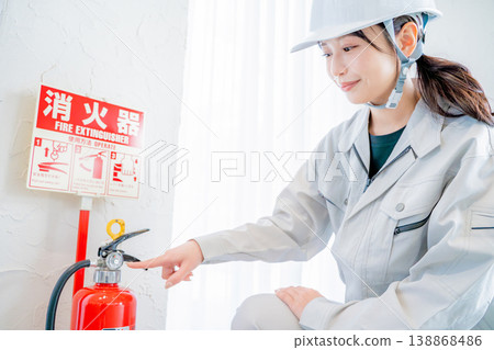 一名身穿工作服的女子正在檢查消防安全設備。 138868486