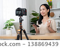 Content Creator in Action: A vibrant woman creates engaging content, skillfully using a camera, smartphone, and laptop to connect with her audience and share her insights. 138869439