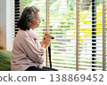 A senior citizen gazes out the window, reflecting on aging and retirement. The loneliness of Alzheimer and depression highlights the importance of compassionate elderly care and support 138869452