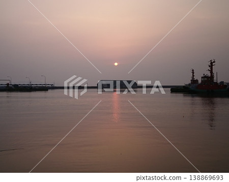 A quiet evening at the industrial port, a sunset, and the reflection of the sky and sea. A quiet evening at the industrial port, a sunset, and the reflection of the sky and sea. 138869693