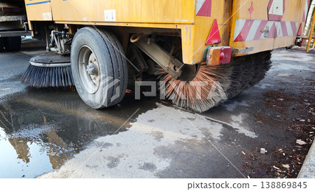 Street cleaning vehicle removing debris from a wet road after rain Street cleaning vehicle removing debris from a wet road after rain 138869845