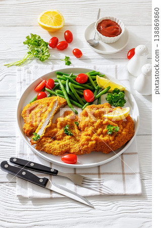 Breaded pork schnitzel with green beans and lemon Breaded pork schnitzel with green beans and lemon 138869860