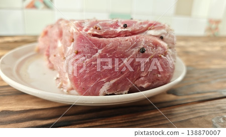 Preparing meat on a plate for cooking in a kitchen setting during daylight Preparing meat on a plate for cooking in a kitchen setting during daylight 138870007