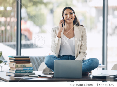 Woman, laptop and phone call and sitting on desk in relax startup, marketing company or advertising business. Smile, happy and talking worker on mobile communication technology, laptop or books study Woman, laptop and phone call and sitting on desk in relax startup, marketing company or advertising business. Smile, happy and talking worker on mobile communication technology, laptop or books study 138870329