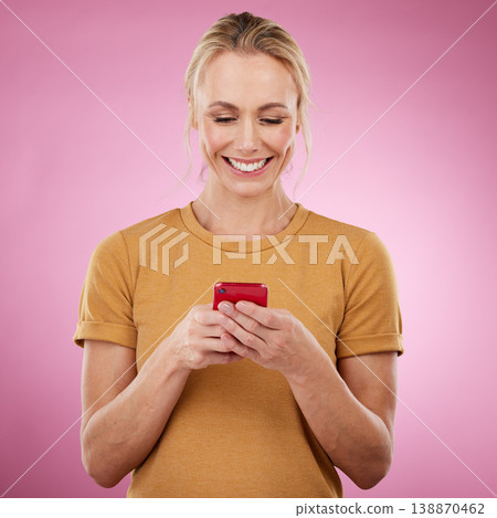 Woman, phone and pink background for communication, social media and online chat in studio. Happy model person with smartphone in hands for network connection or typing post on mobile app or website 138870462