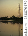The steel high tower for supply the electricity with group of birds in the wetland and clear sunset sky in background 138870479