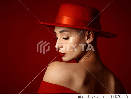 Back, fashion and a model woman on a red studio background for elegant or trendy style. Aesthetic, face and beauty with a young female person in an edgy, classy or unique outfit for a magazine cover Back, fashion and a model woman on a red studio background for elegant or trendy style. Aesthetic, face and beauty with a young female person in an edgy, classy or unique outfit for a magazine cover 138870955