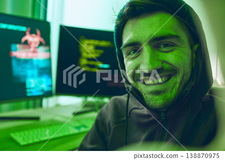 Cybersecurity, crime and smile, portrait of hacker in neon office with code, fraud and virus. Software, ransomware and face of happy man on cyber attack, password thief and online scam with computer. Cybersecurity, crime and smile, portrait of hacker in neon office with code, fraud and virus. Software, ransomware and face of happy man on cyber attack, password thief and online scam with computer. 138870975