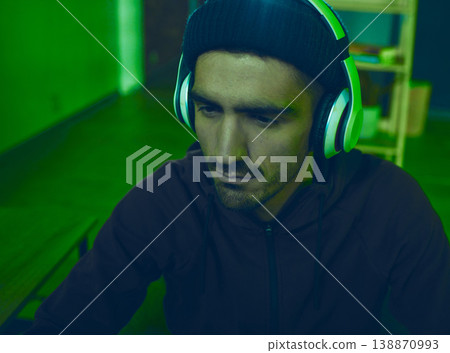 Headphones, man or hacker programming or coding for cybersecurity, online crime or cyber attack. Neon, big data or programmer reading software info for hacking or streaming radio on dark web at night Headphones, man or hacker programming or coding for cybersecurity, online crime or cyber attack. Neon, big data or programmer reading software info for hacking or streaming radio on dark web at night 138870993