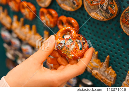 A tourist choosing a pretzel-shaped magnet as a souvenir from their Munich trip. A tourist choosing a pretzel-shaped magnet as a souvenir from their Munich trip. 138871026