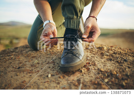 Hands, tie shoes and hiking in nature for travel, training or adventure outdoor. Fitness, sports and person tying laces on sneakers to start workout, walk or running, cardio or workout in countryside Hands, tie shoes and hiking in nature for travel, training or adventure outdoor. Fitness, sports and person tying laces on sneakers to start workout, walk or running, cardio or workout in countryside 138871073