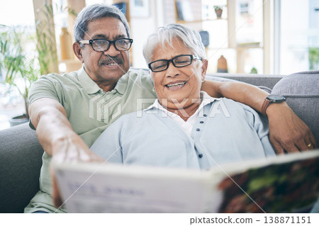 Couple, talking and reading book together on sofa in living room with love, relax and quality time. Senior man, happy woman or partner with glasses, discussion or books on couch at home in retirement 138871151
