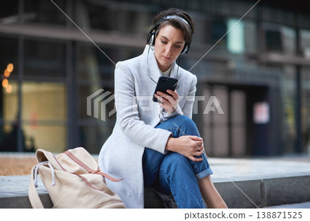 Phone, headphones and business woman in city streaming radio, podcast or music. Technology, cellphone and female entrepreneur with 5g mobile smartphone for networking, social media or web browsing. Phone, headphones and business woman in city streaming radio, podcast or music. Technology, cellphone and female entrepreneur with 5g mobile smartphone for networking, social media or web browsing. 138871525