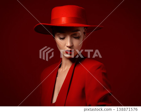 Beauty, fashion and a model woman on red background in studio for elegant or trendy style. Aesthetic, art and confident with an edgy or classy young female person eyes closed in a unique clothes suit 138871576