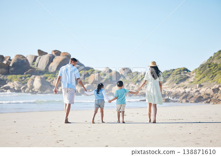 Back, holding hands and a family at the beach for walking, bonding and on a vacation in summer. Care, nature and parents and children with affection while on a walk by the sea during a holiday 138871610