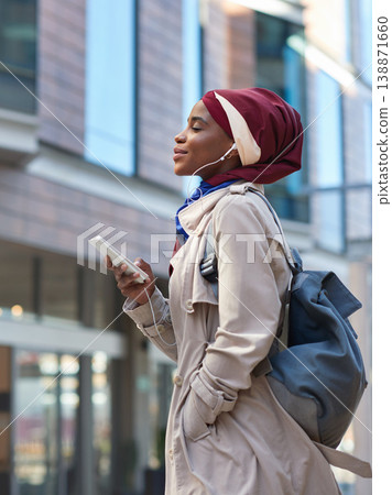 Relax, music and phone with black woman in city for happy and calm, streaming and social media. Technology, internet and radio with muslim girl or student listening to earphones for online podcast Relax, music and phone with black woman in city for happy and calm, streaming and social media. Technology, internet and radio with muslim girl or student listening to earphones for online podcast 138871660