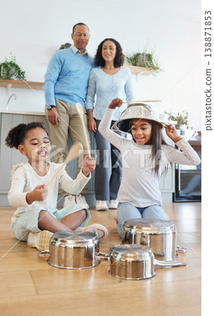 Funny, playing and children with pots for drums with parents watching with love in their home kitchen. Family, happy and crazy playful siblings making noise on metal to play a sound for mom and dad 138871853
