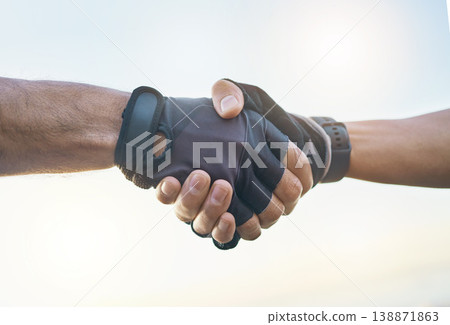 Teamwork, cycling and sports men shaking hands outdoor together against a sky background with flare. Handshake, fitness and partnership with a cyclist team saying thank you during a cardio workout 138871863