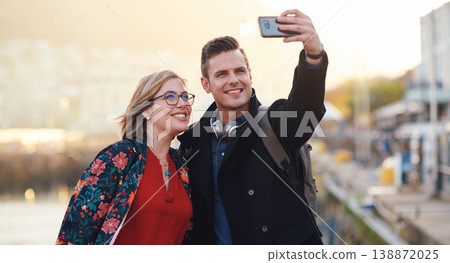 Selfie, travel and couple with phone by harbor enjoying vacation, holiday and honeymoon in Amsterdam. Journey, adventure and happy people take picture for social media, post and memory on smartphone Selfie, travel and couple with phone by harbor enjoying vacation, holiday and honeymoon in Amsterdam. Journey, adventure and happy people take picture for social media, post and memory on smartphone 138872025